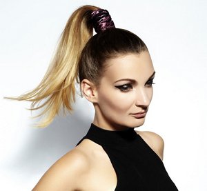 Woman in a black halterneck top with an elegant high ponytail prom hairstyle